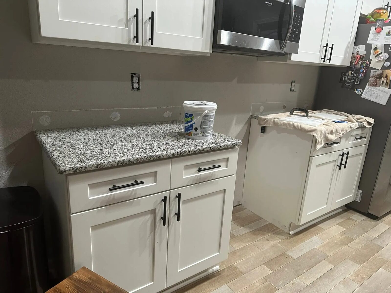 Kitchen mid-renovation with bare wall before backsplash installation